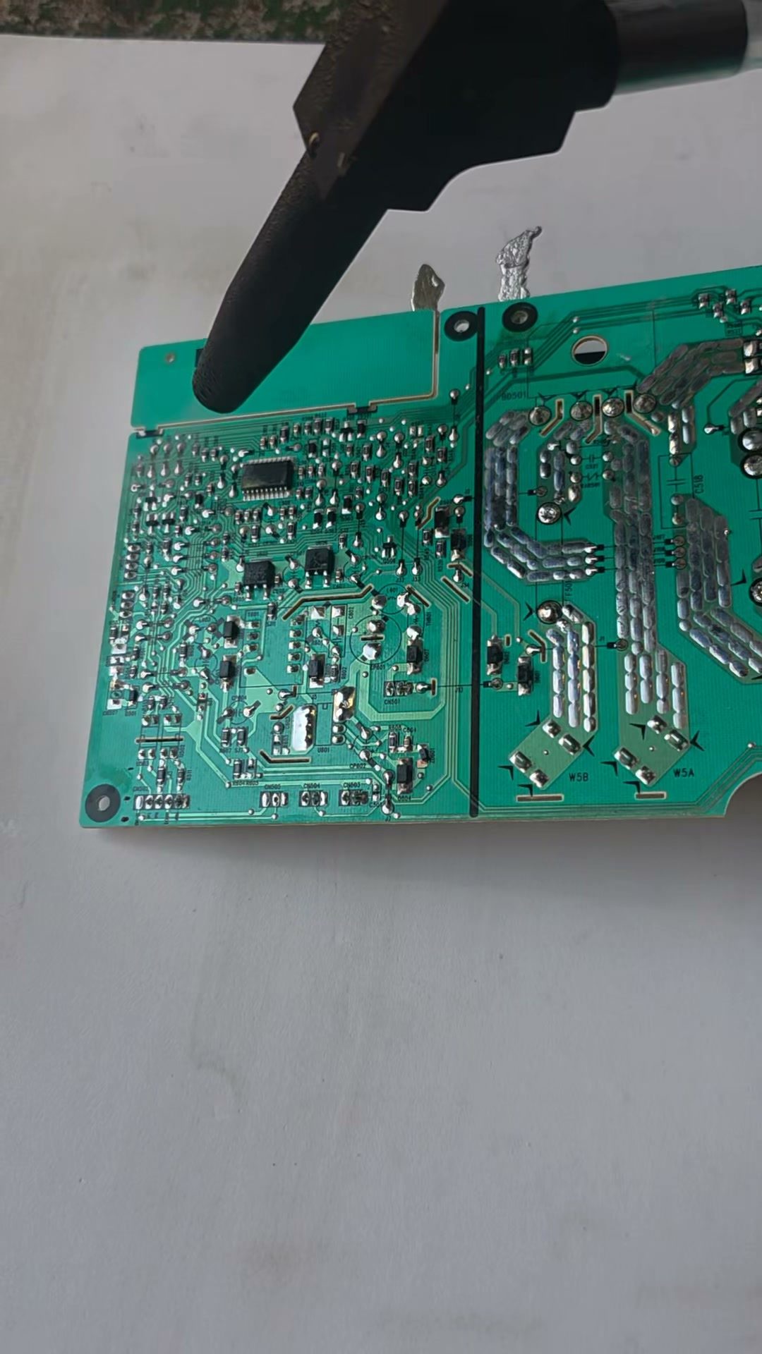 녹색 PCB 기판 표면에 노즐을 대고 드라이아이스로 PCB 세척을 하는 모습